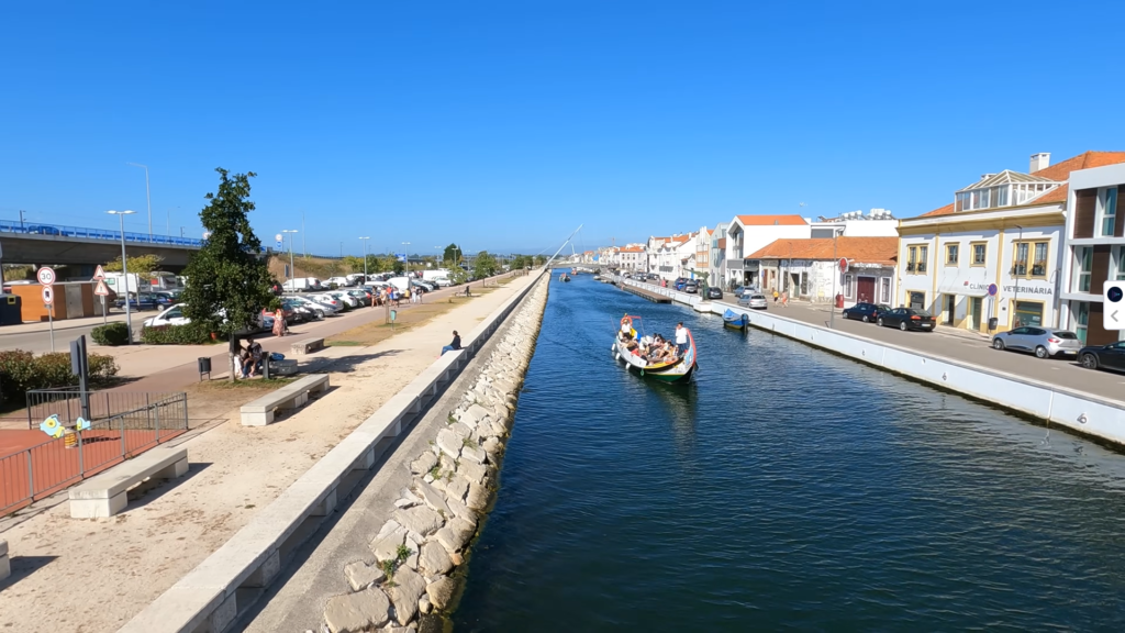 Colorful Moliceiro boat gliding along the canal in Aveiro, adorned with intricate paintings and traditional designs.