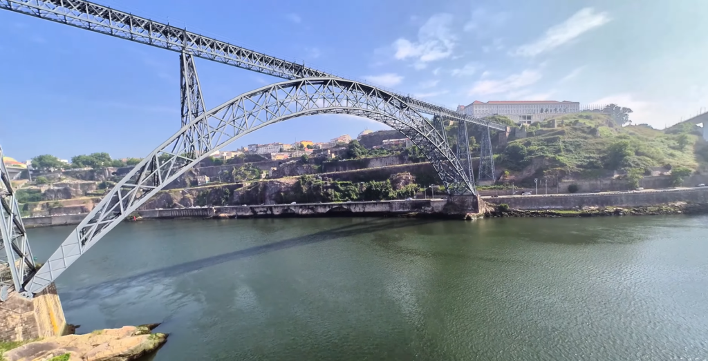 The historic Maria Pia Bridge arching over the Douro River in Porto, a pioneering ironwork structure by Gustave Eiffel.